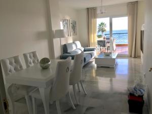 a living room with a white table and chairs at MI CAPRICHO B16 Beachfront Apartment in La Cala de Mijas