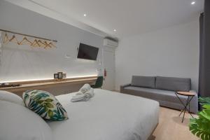 1 dormitorio con cama blanca y sofá en The Match Madrid en Madrid