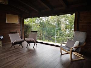 MonzunoにあるAgriturismo Ca' di Mazzaのリビングルーム(椅子2脚、大きな窓付)