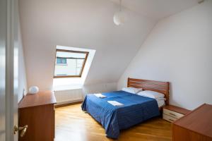 a bedroom with a blue bed and a window at Old Riga Two floor Palasta Loft Apartment with river view in Riga
