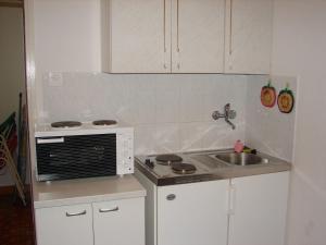 a small kitchen with a sink and a stove at Apartments Jerkica - 50 m from sea in Sutivan