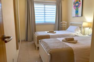 Łóżko lub łóżka w pokoju w obiekcie La Perla Beach Apt with Pool