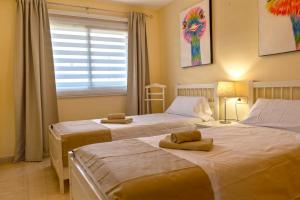 Łóżko lub łóżka w pokoju w obiekcie La Perla Beach Apt with Pool