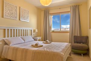 sypialnia z łóżkiem, krzesłem i oknem w obiekcie La Perla Beach Apt with Pool w mieście El Médano