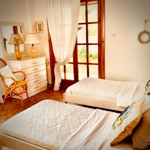 a bedroom with two beds and a dresser and a window at Vravrona Family House in Artemida