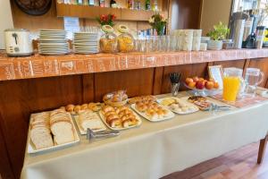 una mesa con varios tipos de pan y repostería. en Hosteria La Pastorella en San Carlos de Bariloche