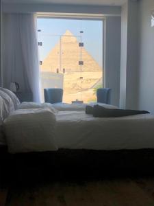 Una cama o camas en una habitación de Cleopatra Pyramids View Hotel