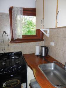 a small kitchen with a stove and a sink at Cabañas Rupel a 3 cuadras del mar in Mar Azul