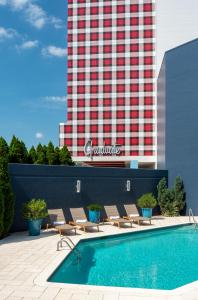 a swimming pool with lounge chairs next to a building at Graduate Fayetteville in Fayetteville