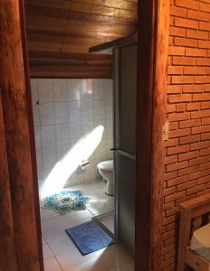 a bathroom with a toilet and a door open at Pousada ao nascer do sol in Gonçalves