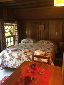 um quarto com uma cama e uma mesa com copos em Pousada ao nascer do sol em Gonçalves