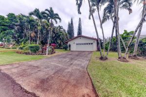 a driveway with palm trees and a white garage at Tiki Hale in Princeville