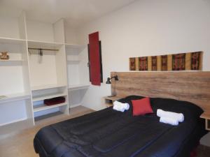 a bedroom with a large black bed with a wooden headboard at Departamentos La Rinconada in Yerba Buena