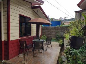 a patio with chairs and a table with an umbrella at Villa Viray in Baguio