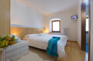 a bedroom with a bed with a blue towel on it at Albergo Cristofoli in Treppo Carnico