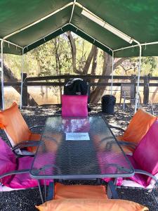 una mesa de cristal y sillas bajo una tienda en Mt Isa City Motel, en Mount Isa