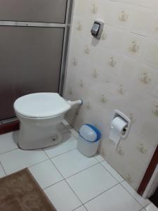 a bathroom with a toilet and a trash can at Suíte bem localizada. in Campos do Jordão