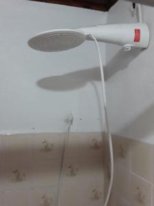 a shower head with a hose hanging from a ceiling at Suíte bem localizada. in Campos do Jordão