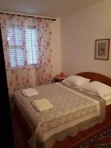 a bedroom with a bed with two towels on it at Apartments Vito - 10 m from sea in Brodarica