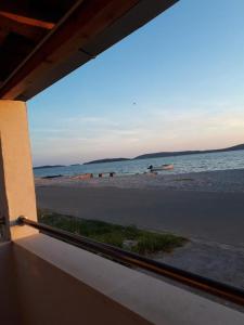 a view of the beach from a window of a beach at Apartments Vito - 10 m from sea in Brodarica