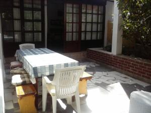 a patio with a table and chairs and a house at Apartments Vito - 10 m from sea in Brodarica