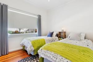 sypialnia z 2 łóżkami i oknem w obiekcie Burnie City Apartments w mieście Burnie