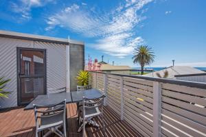 a patio with a table and chairs on a deck at Burnie City Apartments in Burnie