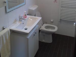 a white bathroom with a sink and a toilet at Apartment Nikola M - 2 bedrooms in Bol