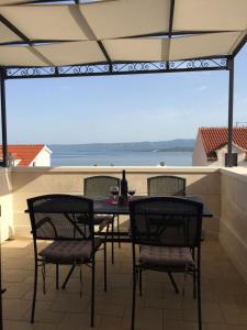 a table and chairs on a patio with a view of the ocean at Apartment Nikola M - 2 bedrooms in Bol