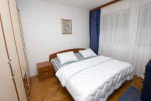 a bedroom with a bed with two pillows on it at Apartment Jerko - 200 m from beach in Omiš