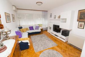 uma sala de estar com um sofá e uma televisão em Apartment Jerko - 200 m from beach em Omiš