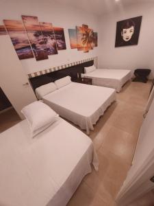 Pokój z 3 łóżkami i obrazami na ścianie w obiekcie LOFT STAR THE PALMER HOUSE w Madrycie