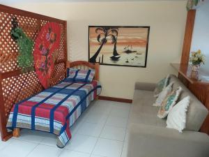 Habitación con cama, sofá y pintura en Conjugado Don Quijote 01, en Búzios