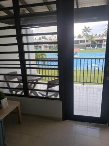 Habitación con ventanas y vistas a la piscina. en Relax Beachfront Complex at Rio Grande, en Río Grande