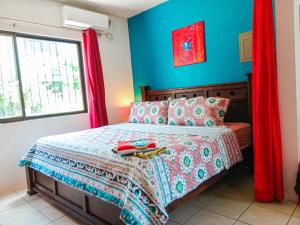 a bedroom with a bed with blue walls and red curtains at Studio Apartments in Las Torres in Coco
