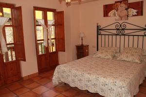 a bedroom with a bed and two windows at Casa Rural La Torre De Babel in Molinaseca