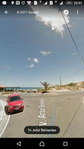 un coche aparcado en un estacionamiento junto al océano en Casa Travessa Artur Bernardes 25, en Arraial do Cabo
