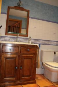 a bathroom with a sink and a toilet and a mirror at Casa Rural La Torre De Babel in Molinaseca