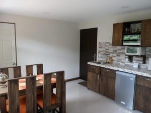 cocina con mesa y sillas en una habitación en CASA GERANIOS # 2, en Monteverde