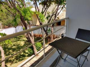 a table and chair on a balcony with a tree at Flat Pé de Mamão in Campinas