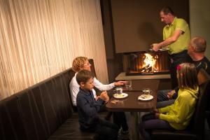 a group of people sitting around a table in a restaurant at Hotel Center Pokljuka in Goreljek