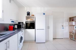 a kitchen with white appliances and a white refrigerator at OCEANE***route des plages***Marina***wifi in Le Marin