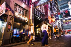 um grupo de pessoas andando por uma rua à noite em Butterfly on LKF, Central em Hong Kong
