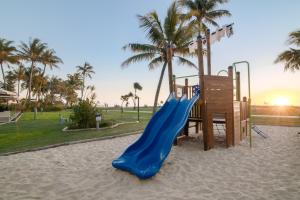 a playground with a blue slide in the sand at Tangalooma Island Resort in Tangalooma