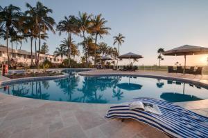 - une piscine dans un complexe avec des palmiers dans l'établissement Tangalooma Island Resort, à Tangalooma