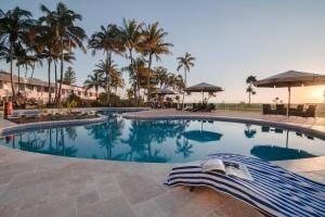 a swimming pool in a resort with palm trees at Tangalooma Island Resort in Tangalooma