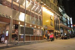 a city street at night with people walking in front of buildings at Butterfly on Wellington, Central in Hong Kong