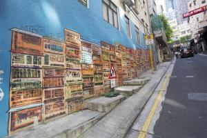 a mural on the side of a building with benches at Butterfly on Wellington, Central in Hong Kong