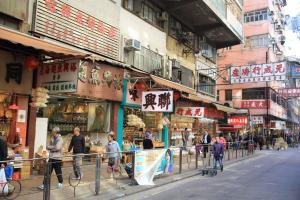 a group of people walking around a street with buildings at Butterfly on Wellington, Central in Hong Kong