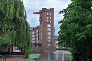 ヨークにあるSerenity Inn the Cityの川の横に塔のあるレンガ造りの建物